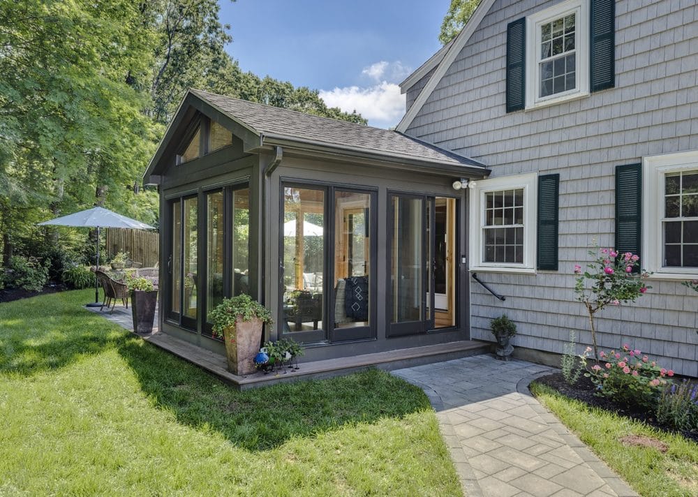 A Four-Season Sunroom Design with oak wood glass panels and pine floors